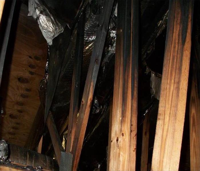 blackened roof rafters and damaged insulation from a house fire