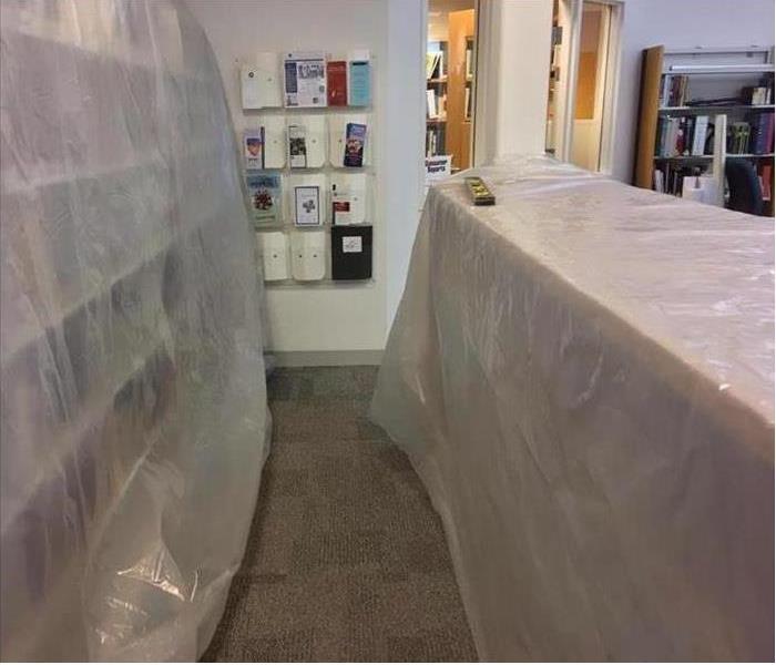 bookcases covered with plastic sheeting